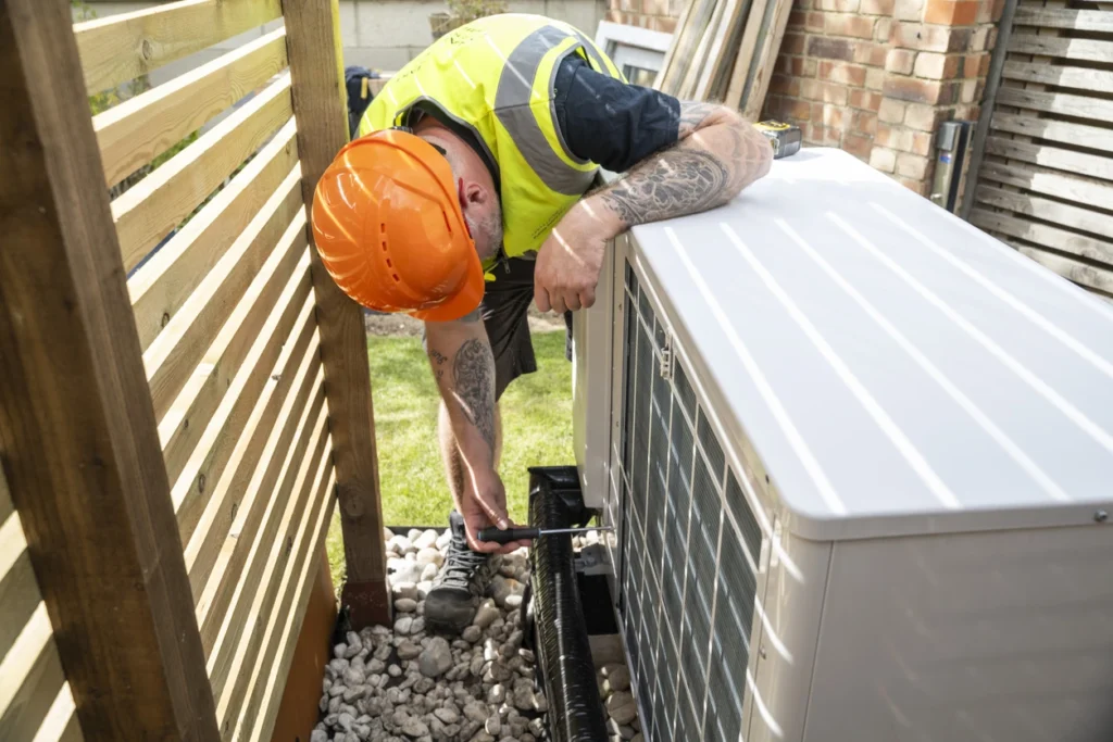 A professional technician repairs a heat pump system